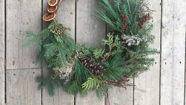 holiday wreath hangs on a wooden door