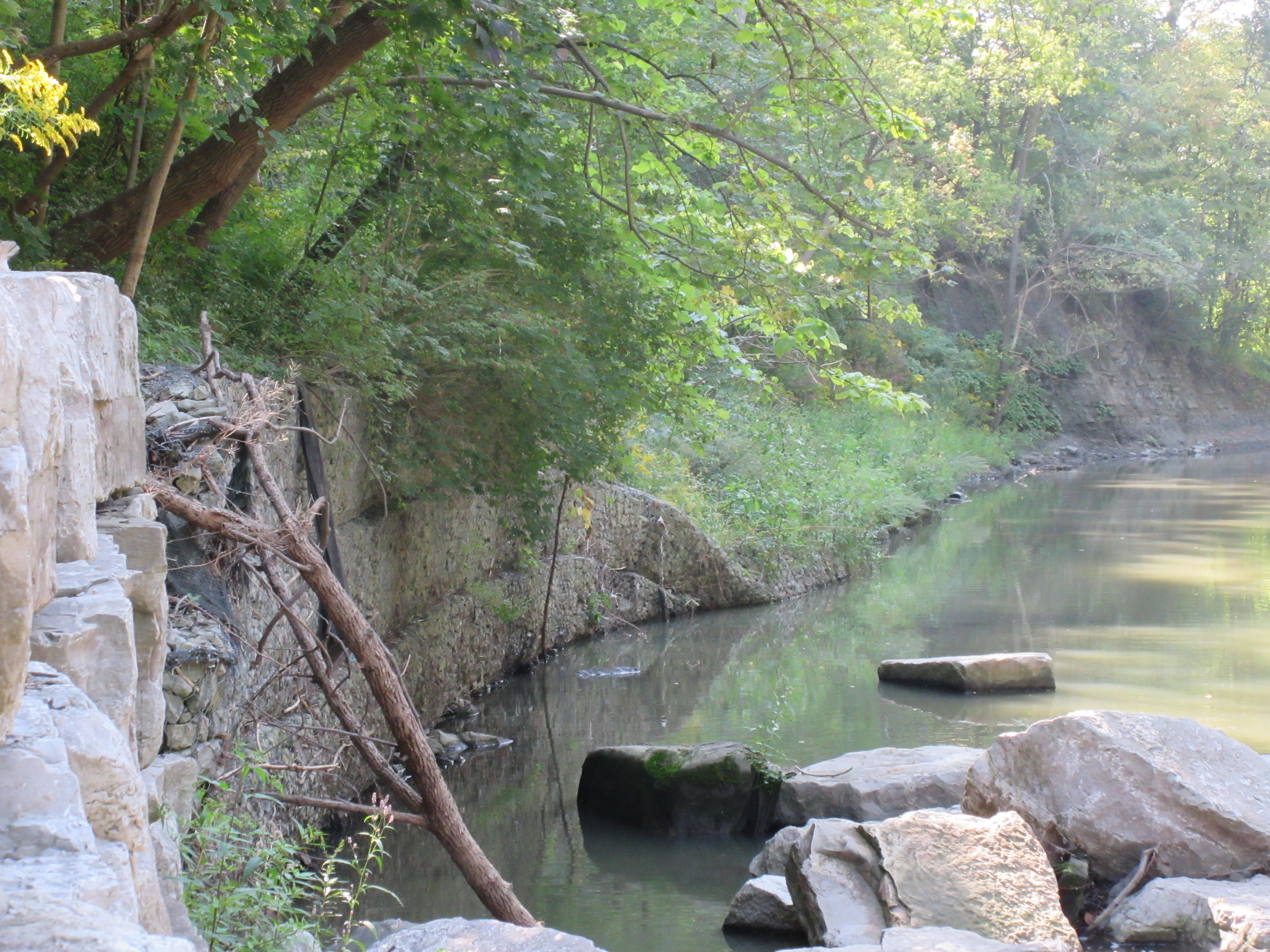 Part of a gabion basket wall sliding into a creek