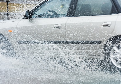 car drives through flood waters