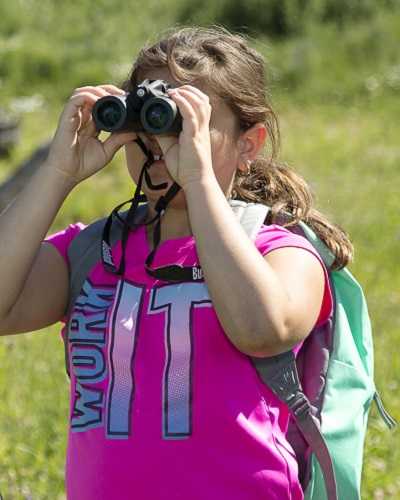 camper learns to use binoculars during outdoor summer nature camp at Claireville Conservation Area