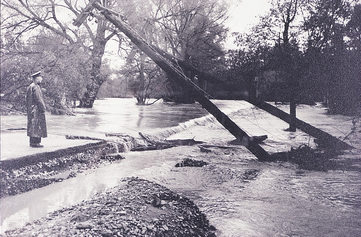 archival photograph of police officer surveying the aftermath of Hurricane Hazel