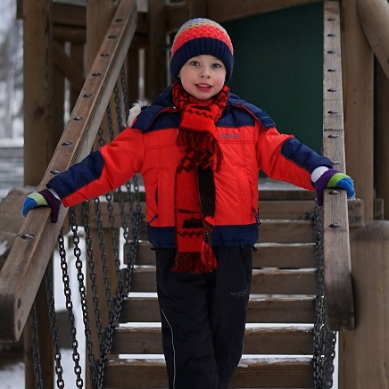 child enjoys time in the playground after winter walk to school