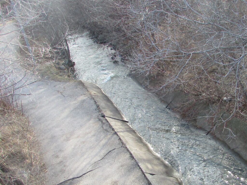 Photo of project site before construction. The site includes a concrete channel and rip rap revetment along Etobicoke Creek, adjacent to Chinguacousy Trail.