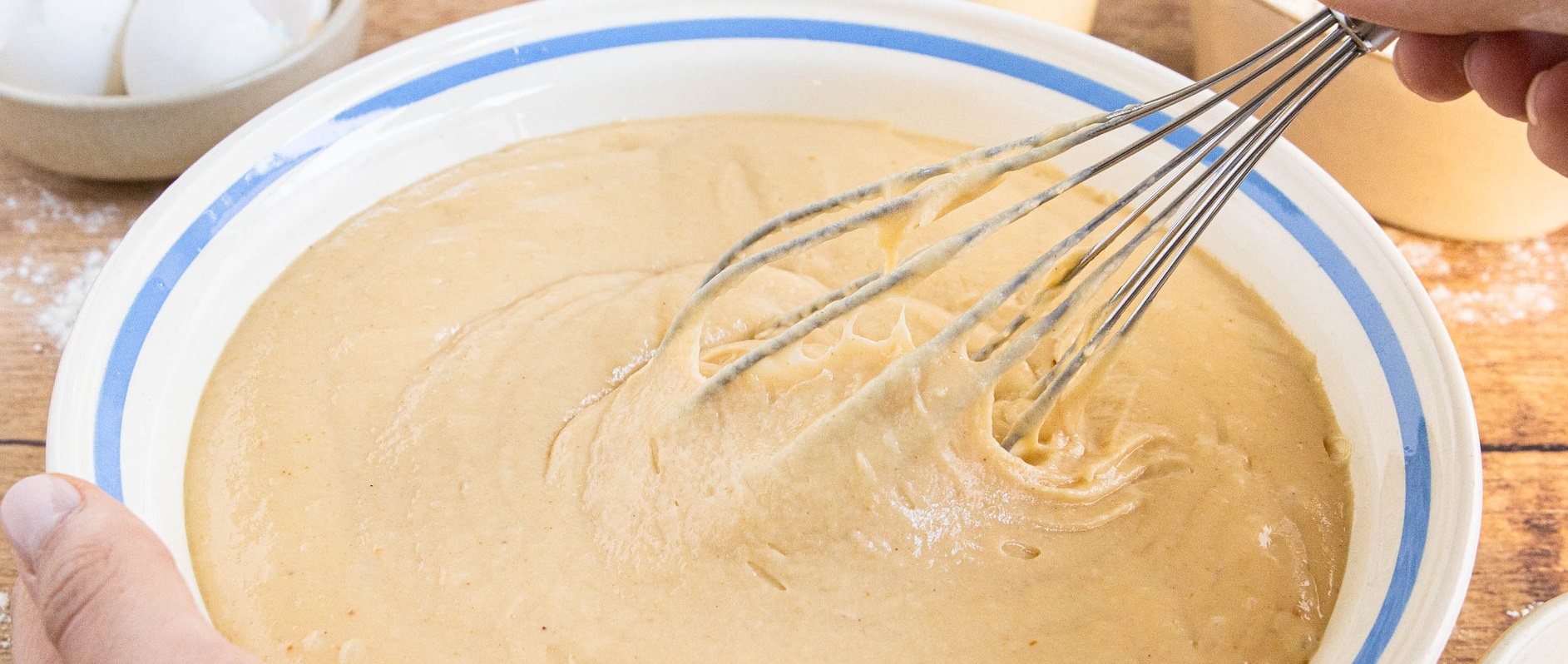 baker uses wire whisk to mix batter for maple cake