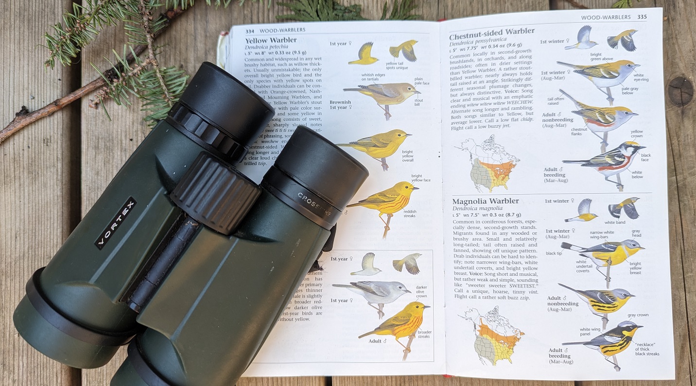 a pair of binoculars and a field guide to the birds of southern Ontario