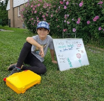 Evan Huynh on his front lawn welcoming his neighbours to learn about butterflies and collecting donations for TRCA