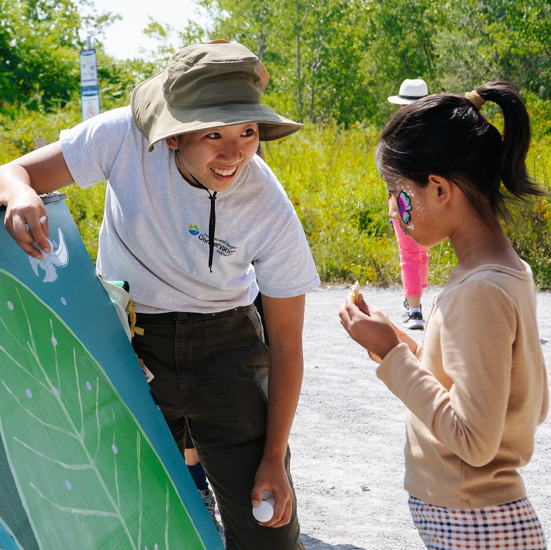 TRCA educator greets young visitor to the Butterfly Festival at Tommy Thompson Park