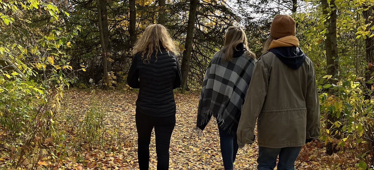 friends enjoy an autumn walk on a trail at Kortright Centre