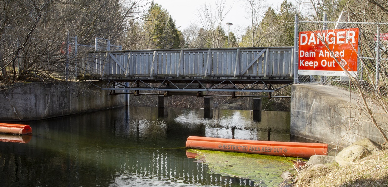 a bright red danger sign warns community members to exercise caution near Palgrave Dam