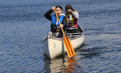 campers learn to paddle a canoe at summer camp at Lake St George Field Centre