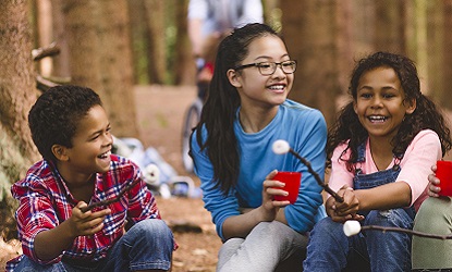 summer campers toast marshmallows around a campfire at Claireville Outdoor Education Centre