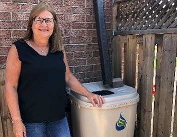 a West Bolton SNAP homeowner installs a rain barrel on her property