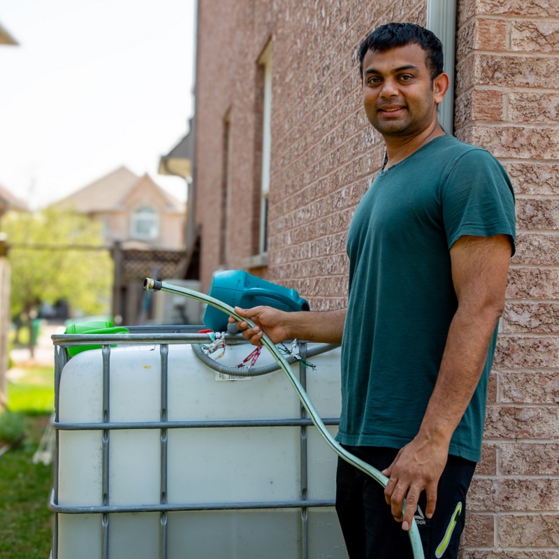 a West Bolton SNAP neighbourhood homeowner installs a rain barrel on his property