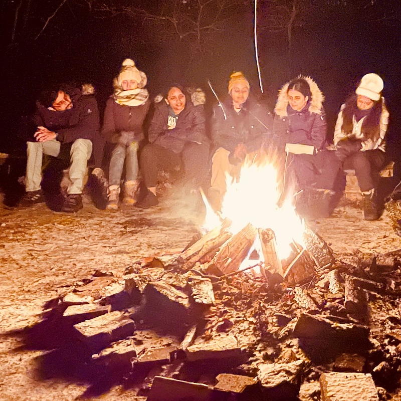 students gather around a campfire at an overnight camp at a TRCA outdoor education centre
