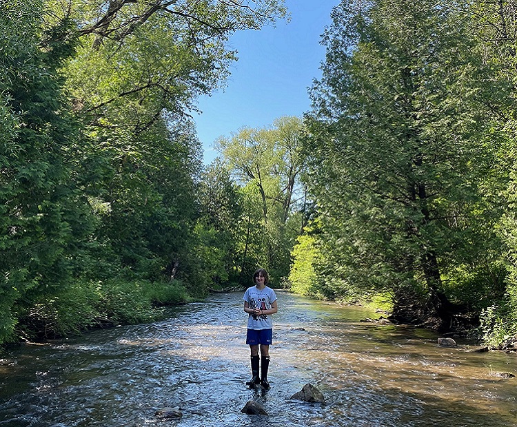 a student explores a stream at Claremont Nature Centre on an overnight field trip