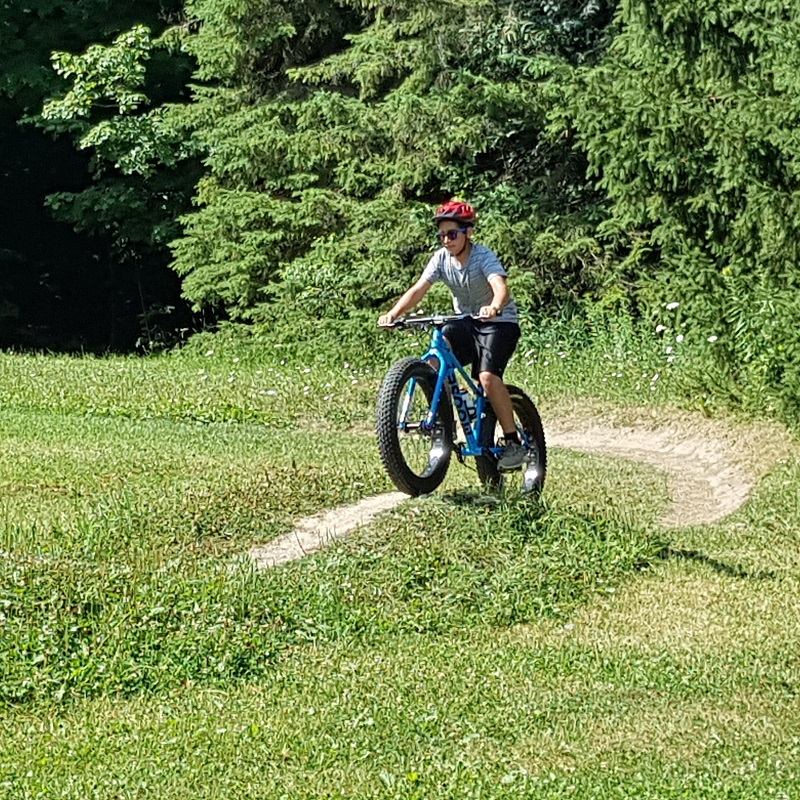 a student on a field trip rides a fat tire bike on a trail at Albion Hills Field Centre