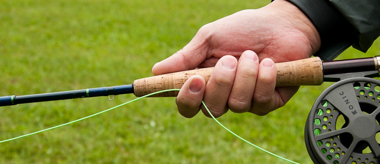 an angler holds a fishing rod in his right hand