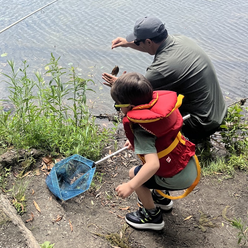 an experienced angler teaches a youngster to fish