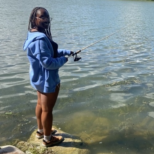 a young woman enjoys fishing at Heart Lake Conservation Park