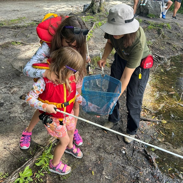 a young angler in the TRCA Learn to Fish program views a small fish caught in a net