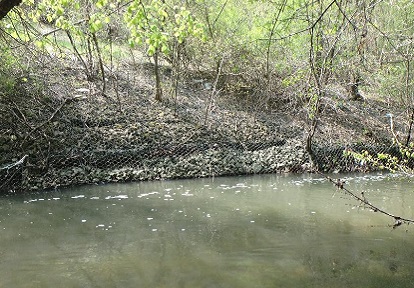 the Canyon Avenue erosion control structure shows loss of rock fill and structural integrity