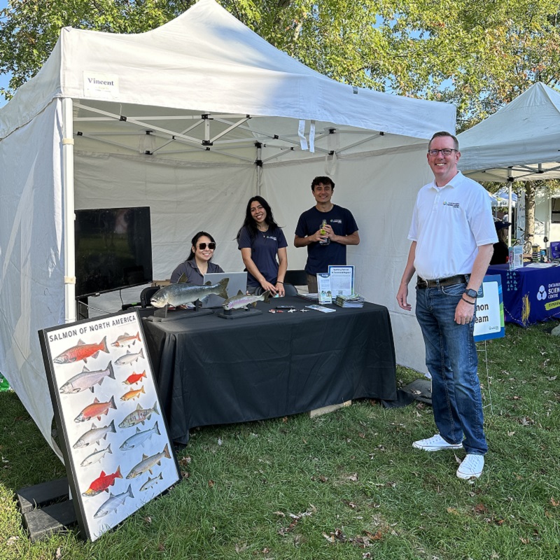 TRCA team members at an interactive education booth greet visitors to the TRCA Adventures of Salmon event in Morningside Park