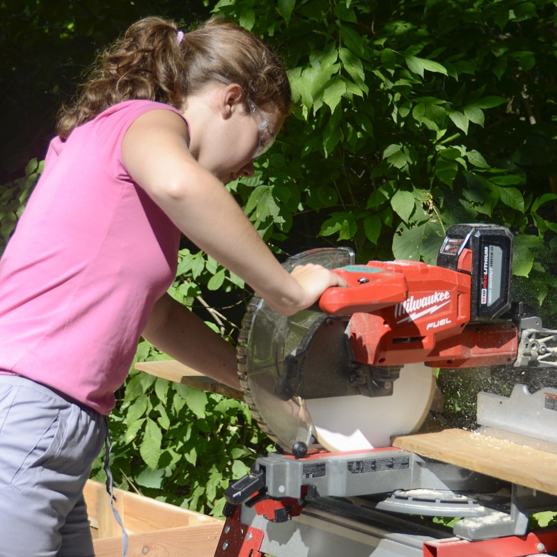 a Girls Can Too program participant uses a power saw