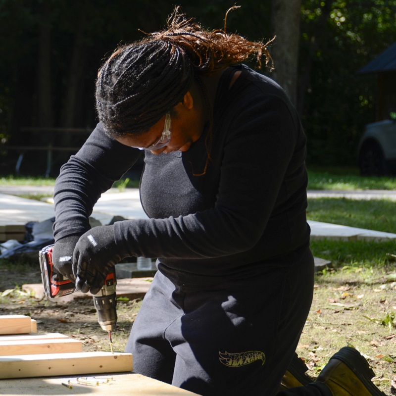 a Girls Can Too program participant uses a power drill