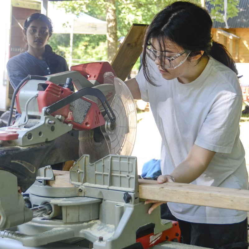 a Girls Can Too program participant uses a power saw
