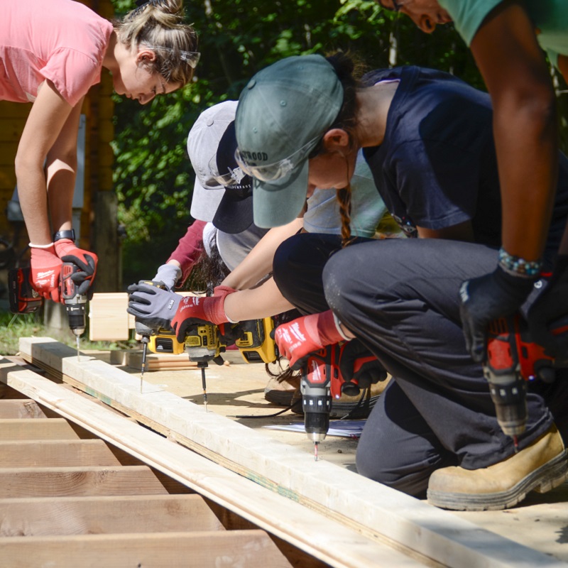 a group of Girls Can Too program participants work together on a construction project