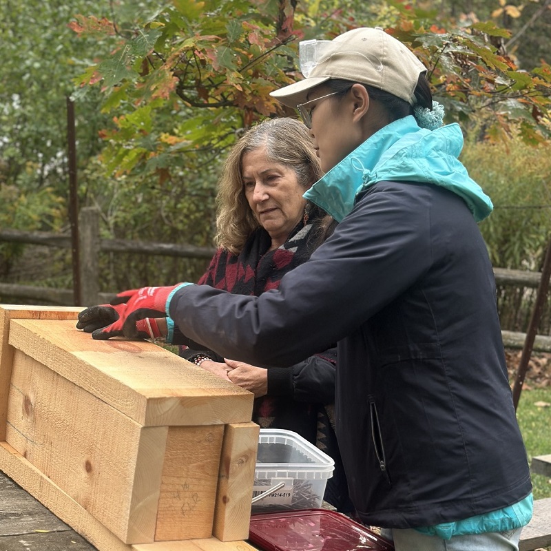 a Girls Can Too program instructor demonstrates building techniques to a visiting dignitary at the 10 year anniversary celebration