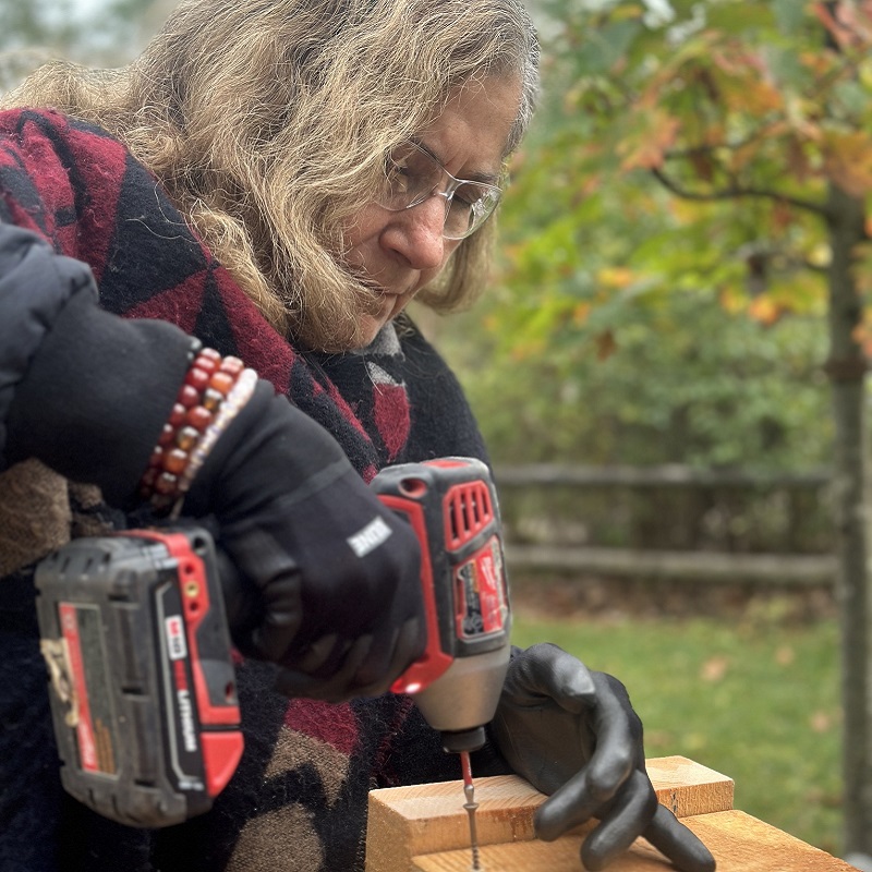 a visiting dignitary takes part in a building project at the 10 year anniversary celebration of the Girls Can Too program