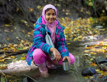 a student at The Nature School at Claireville Outdoor Education Centre explores a stream bed