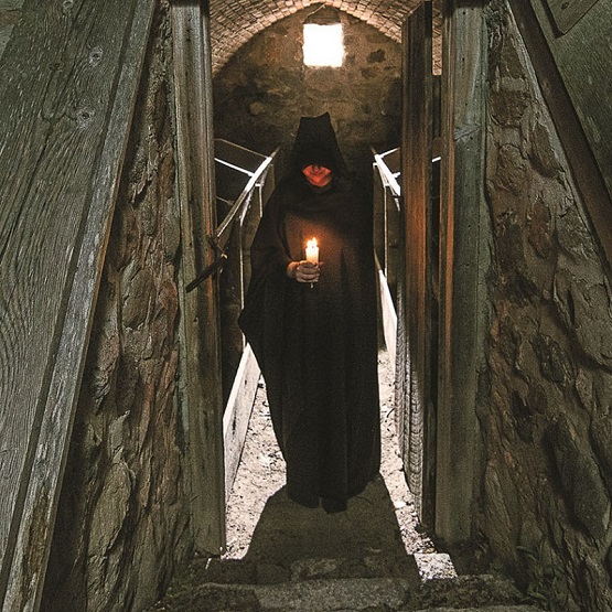 a dark cloaked figure stands at the bottom of the steps to the apple cellar at The Village at Black Creek