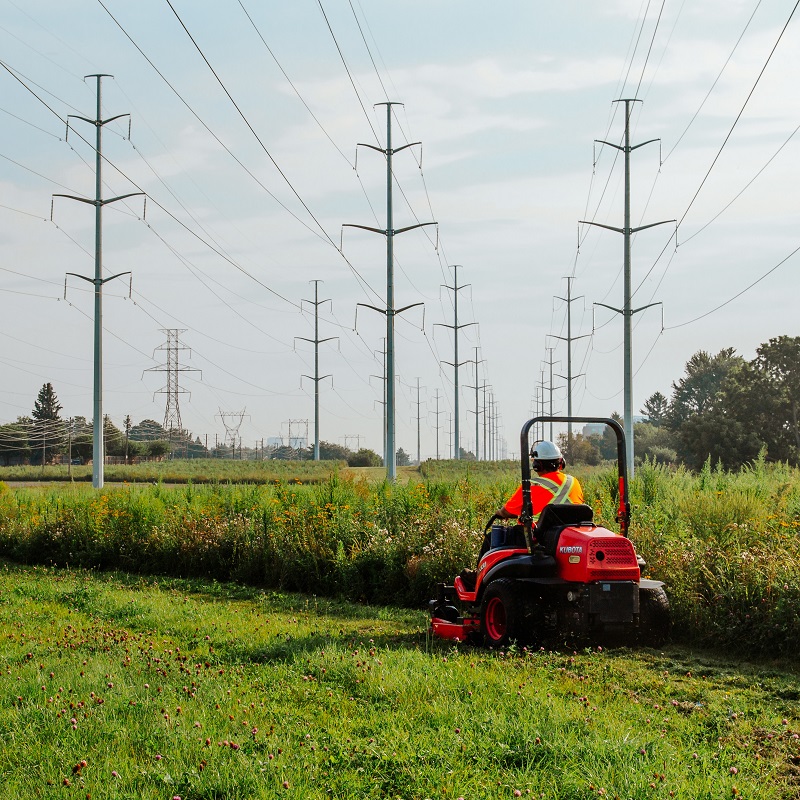 a TRCA restoration team member uses a riding mower to trim the borders of a meadow habitat