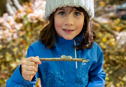 a student in The Nature School program at Claremont Nature Centre in Pickering examines a caterpillar
