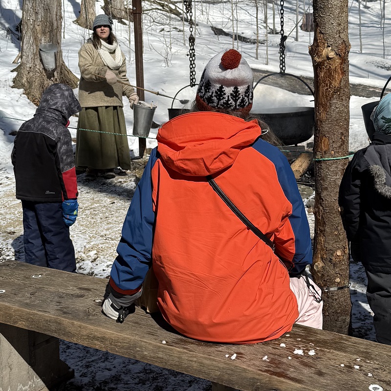 community members enjoy a demonstration of the traditional method of making maple syrup