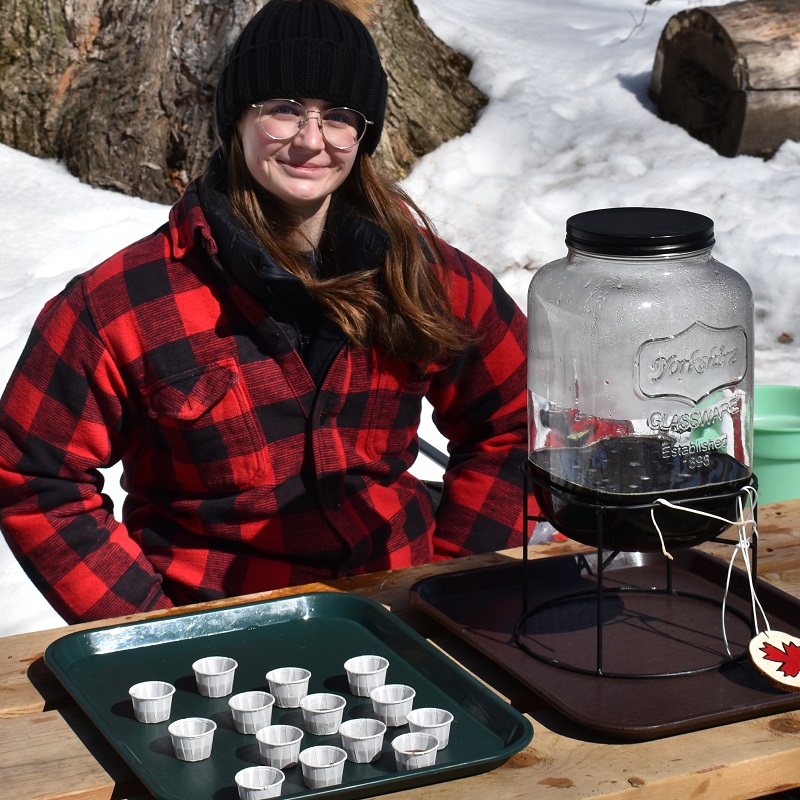 a TRCA team member greets visitors to the annual Maple Syrup Festival at Kortright Centre for Conservation in Vaughan