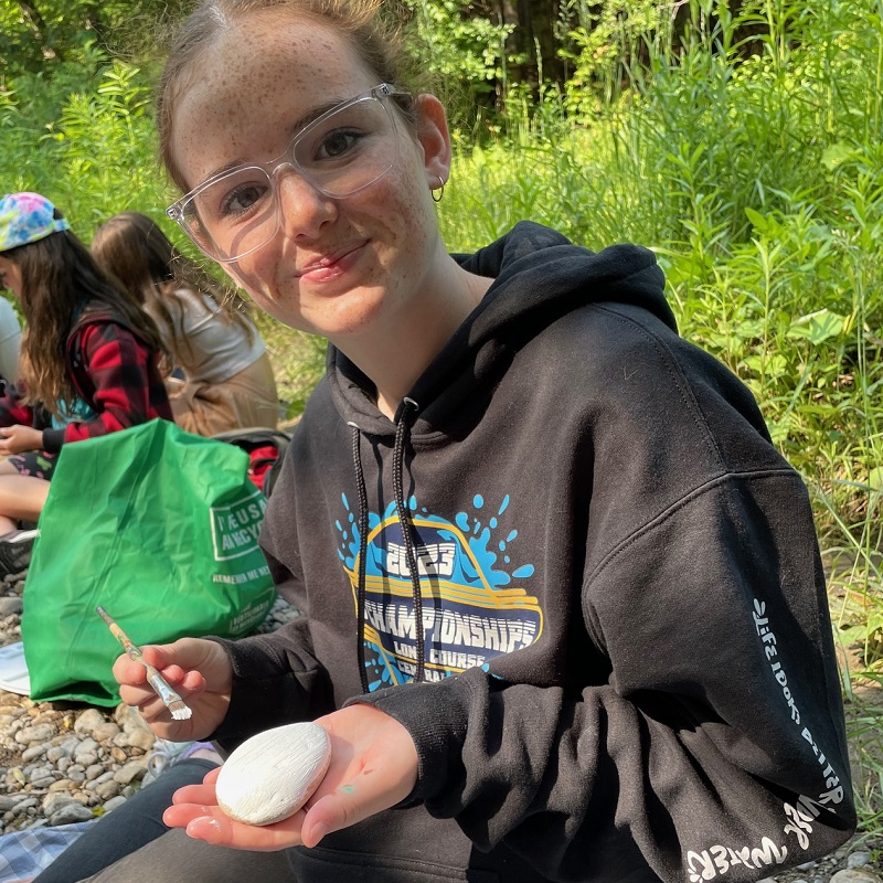 a student taking part in a community group program makes nature art at Claireville Conservation Area in Brampton