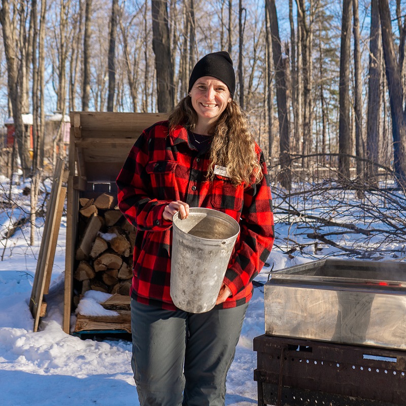 a TRCA educator at the Sugarbush Maple Syrup Festival at Bruces Mill Conservation Park demonstrates the traditional method of making maple syrup