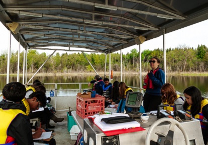 a TRCA educator leads a high school science lab on the pontoon boat at Lake St George Field Centre