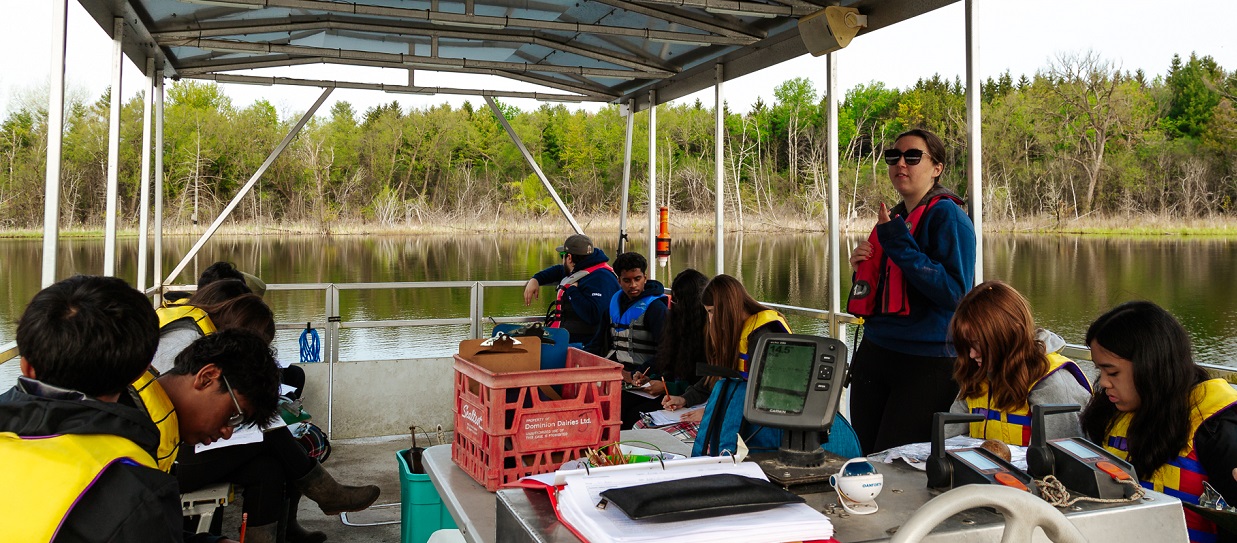 a TRCA educator leads a high school science lab on the pontoon boat at Lake St George Field Centre