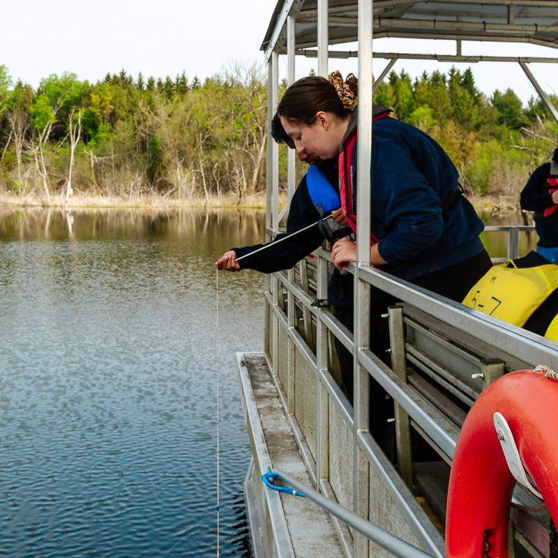 students on a high school science lab field trip to Lake St George Field Centre collect water samples for analysis