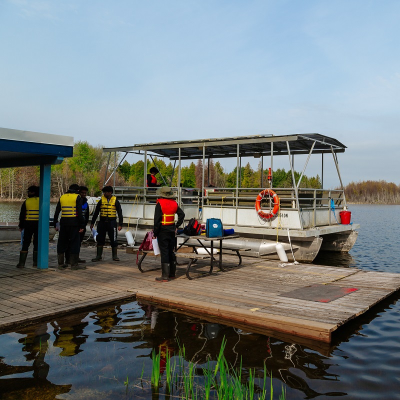 high school students prepare for a science lab aboard the solar powered pontoon boat at Lake St George Field Centre