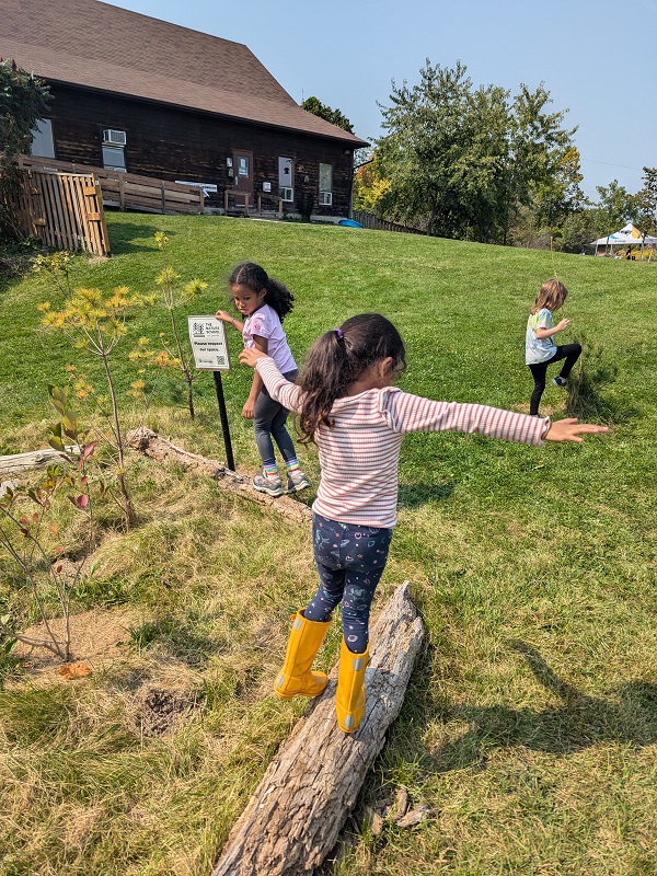 students balance on logs during a weekend nature club program at Claireville Outdoor Education Centre