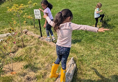 students balance on logs during a weekend nature club program at Claireville Outdoor Education Centre