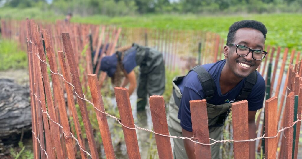 a Ravine Youth Team crew member works at a wetland habitat restoration project site