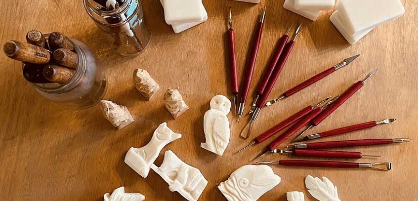a display of soap carvings and the artist tools for creating them