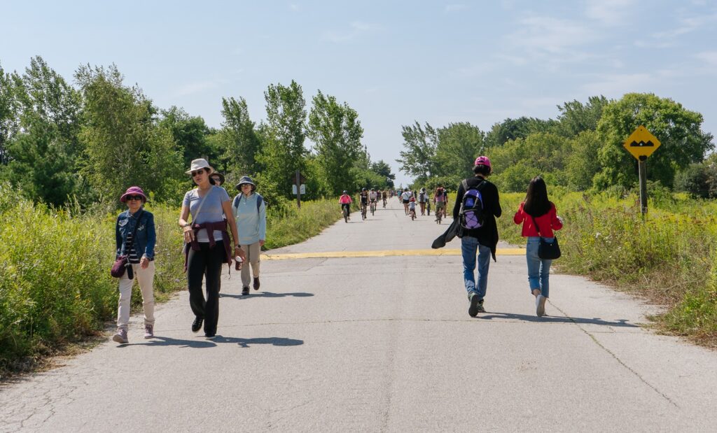 visitors explore a trail at Tommy Thompson Park both on foot and on bicycle