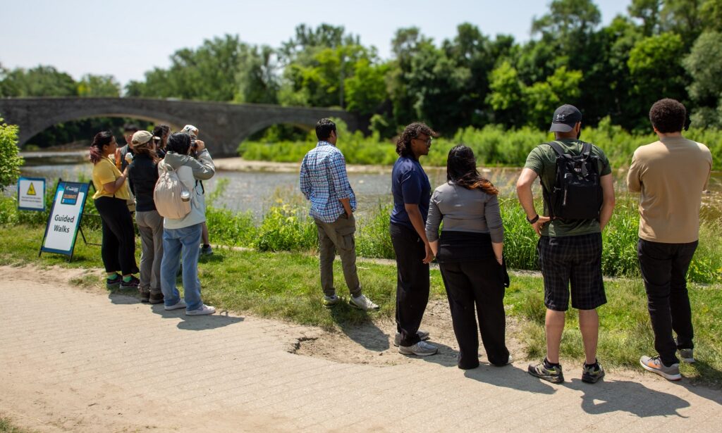 visitors to the TRCA Celebrate the Humber event gather on the banks of the river for a guided tour